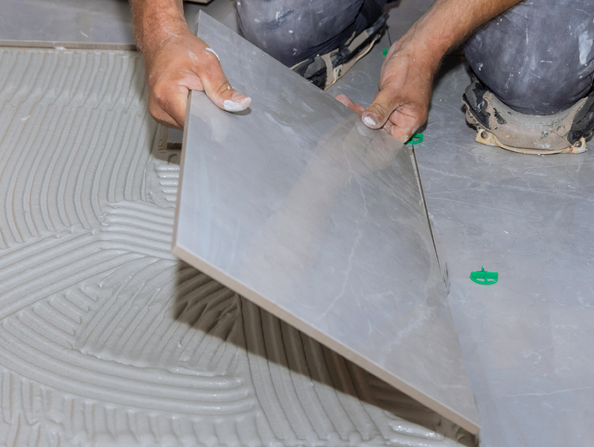 A tile installer remodeling a bathroom.