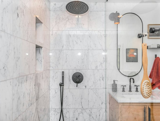 A beautiful new shower with marbled tiles.