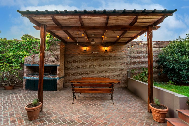 Covered outdoor seating area with custom herringbone patterned masonry.