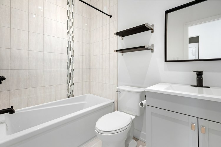 Remodeled tub and shower with matte black finishes.