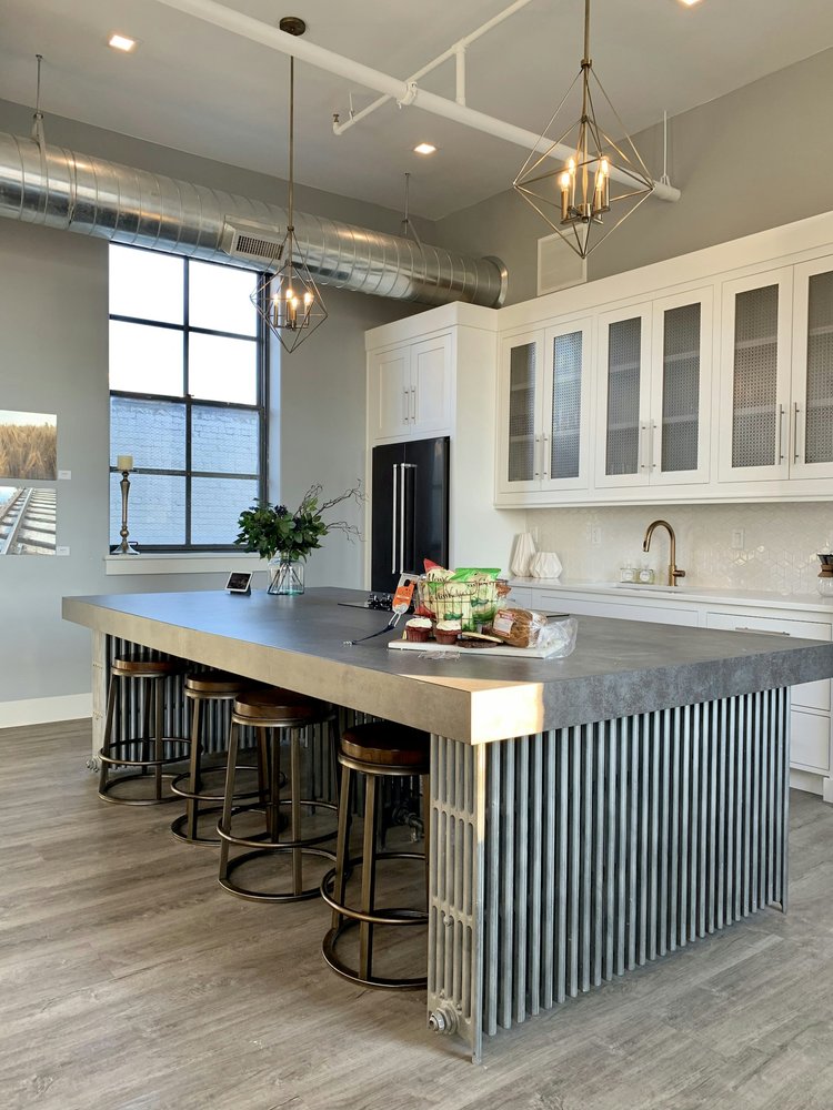 Large apartment kitchen with high ceilings. Custom kitchen island with large bar and stools.