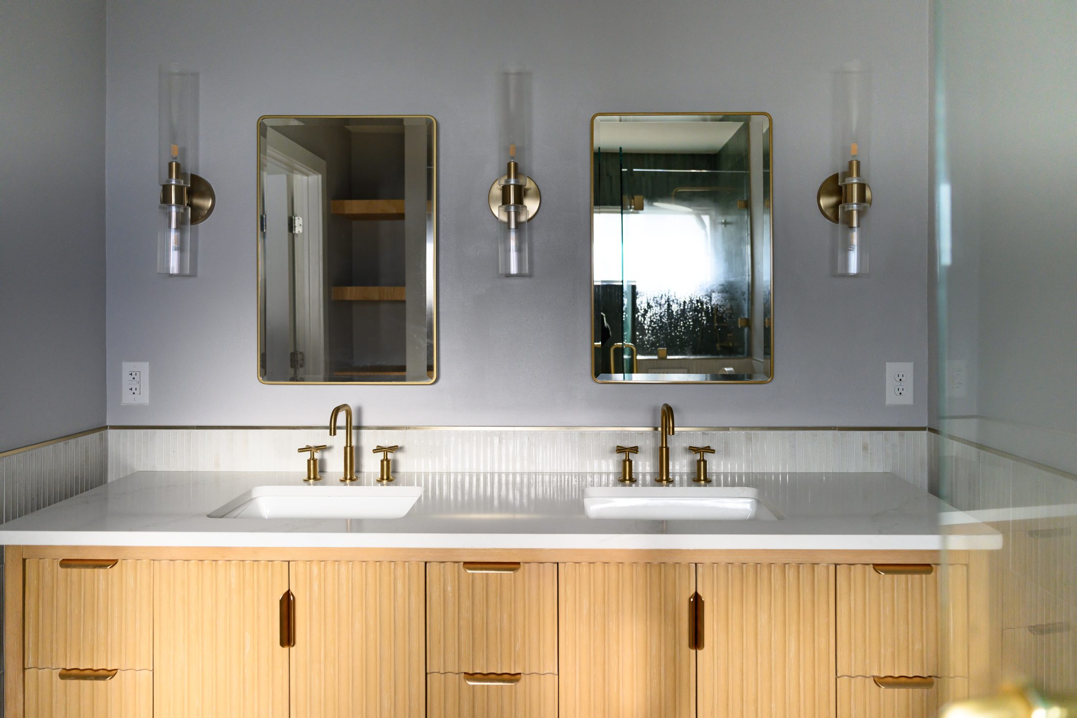 Finished Georgetown bathroom vanity with mirrors, sconces, and double sinks