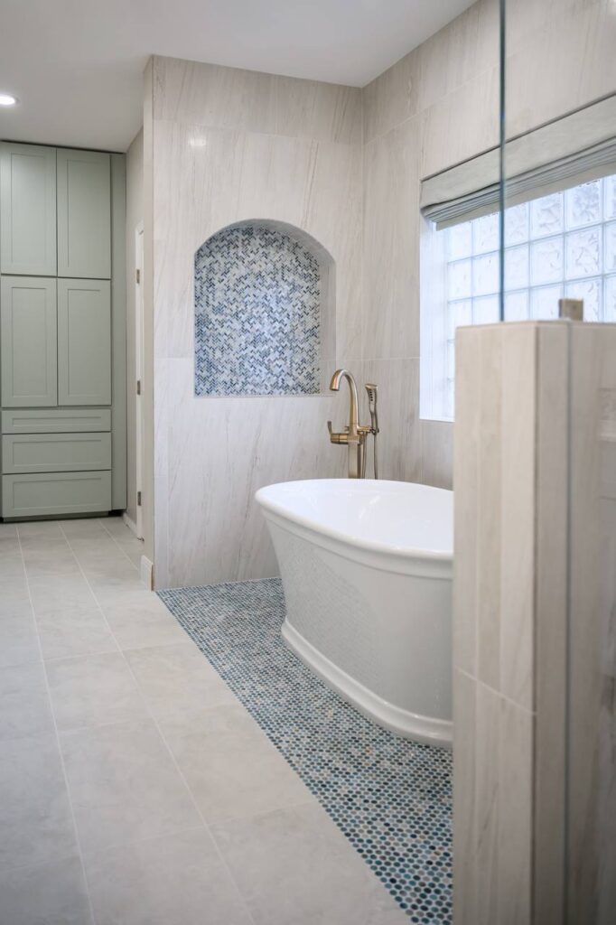 Spanish Oak tub niche and mosaic floor with marble-look shower walls