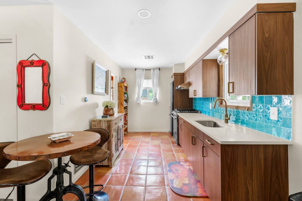 E 18th Street kitchen with walnut cabinets, terracotta tile floor, turquoise backsplash