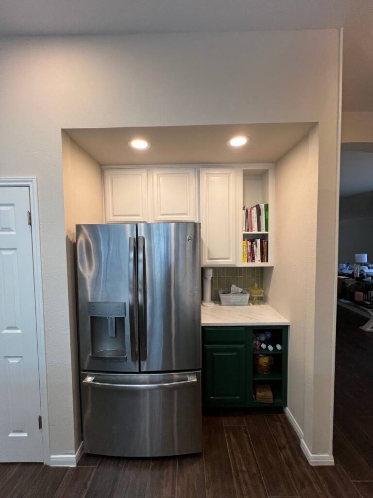Dapplegrey refrigerator nook with white cabinetry, quartz counter, built-in bookcase storage
