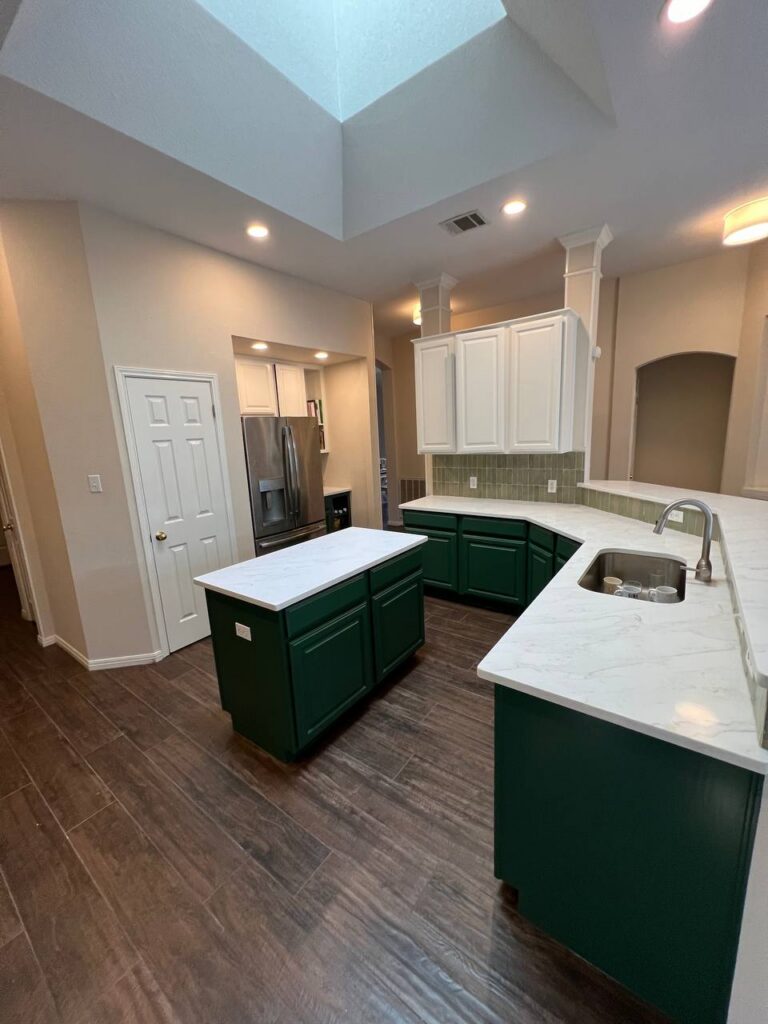 Dapplegrey kitchen peninsula with green cabinets, quartz counters, skylight, stainless appliances
