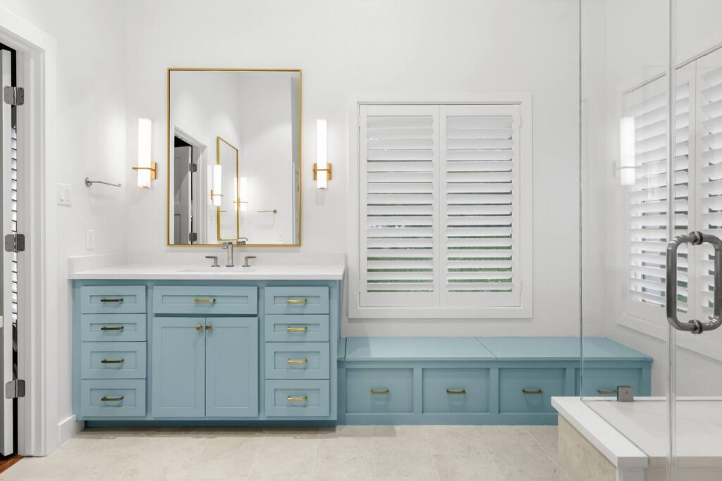 Hedgebrook Way primary bathroom with blue double vanity and brass mirrors