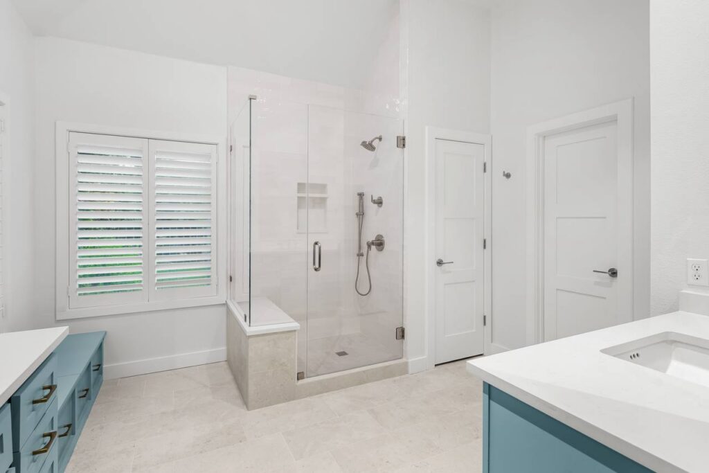 Hedgebrook Way shower with glass enclosure, pale tile, and built-in bench