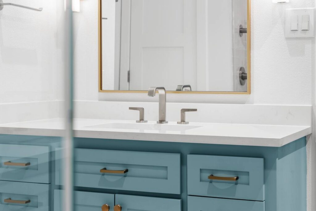 Hedgebrook Way vanity close-up with blue drawers and brushed brass pulls