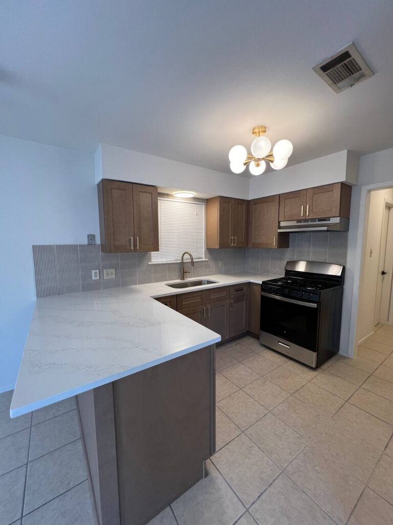 Thornridge Dr. kitchen with brown cabinets, white quartz island, and tile backsplash