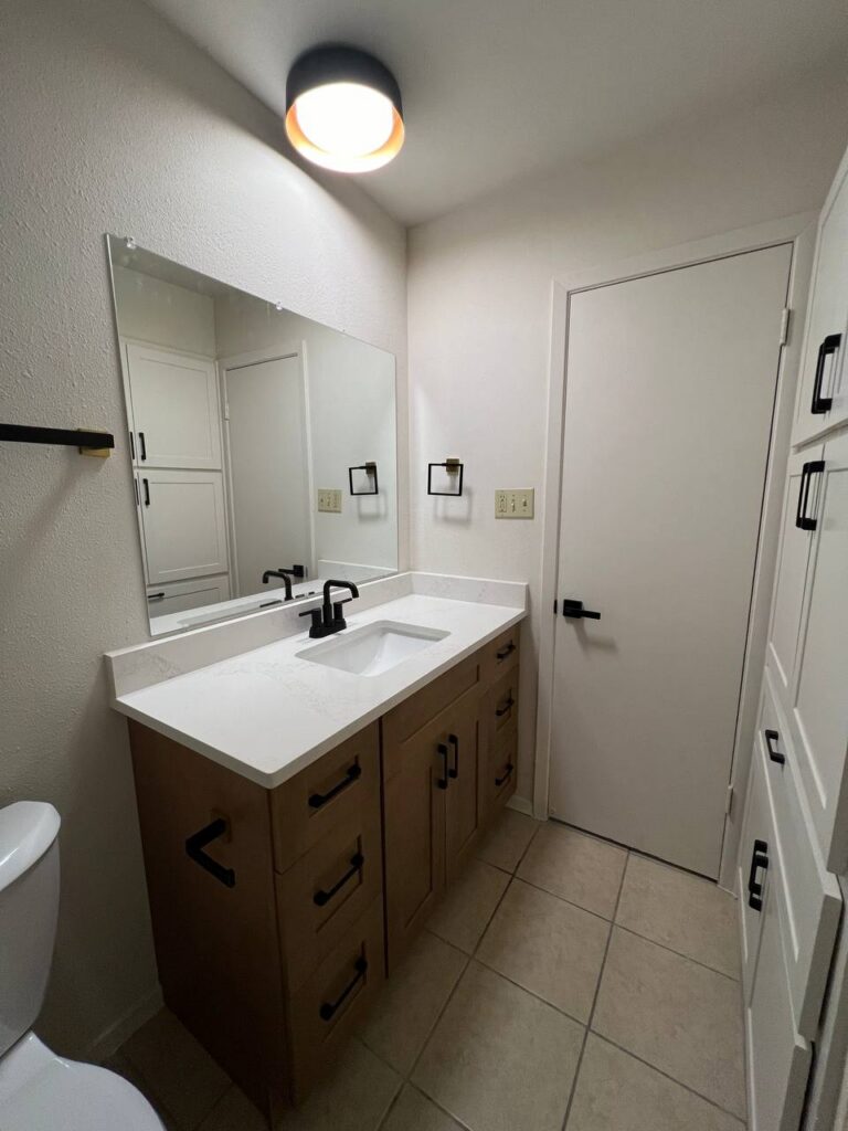 Thornridge Dr. bathroom vanity with quartz top, wood cabinetry, and matte black fixtures