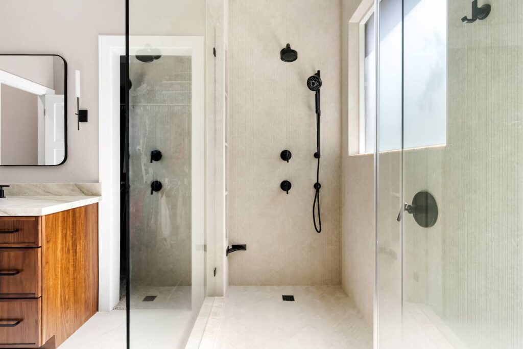 Annadale Dr. shower and vanity view with frosted glass, black hardware, warm wood